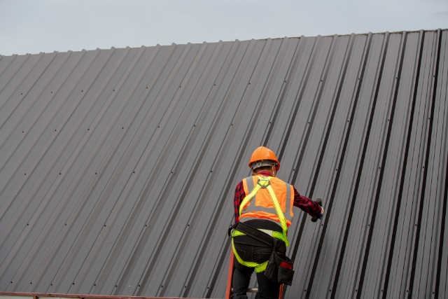 Roofer Installing Metal Sheet